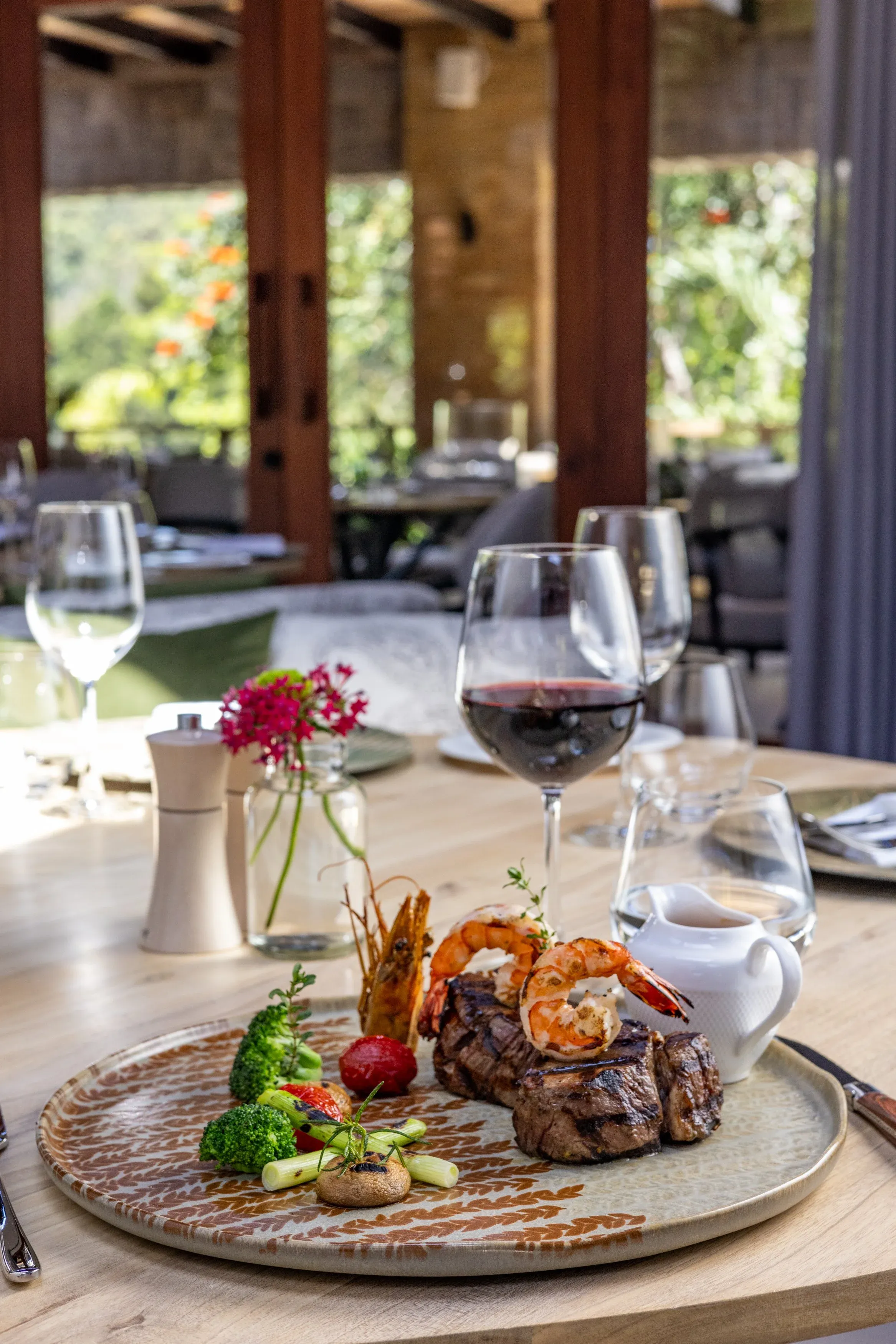 Surf and turf with red wine on a table overlooking the garden terrace