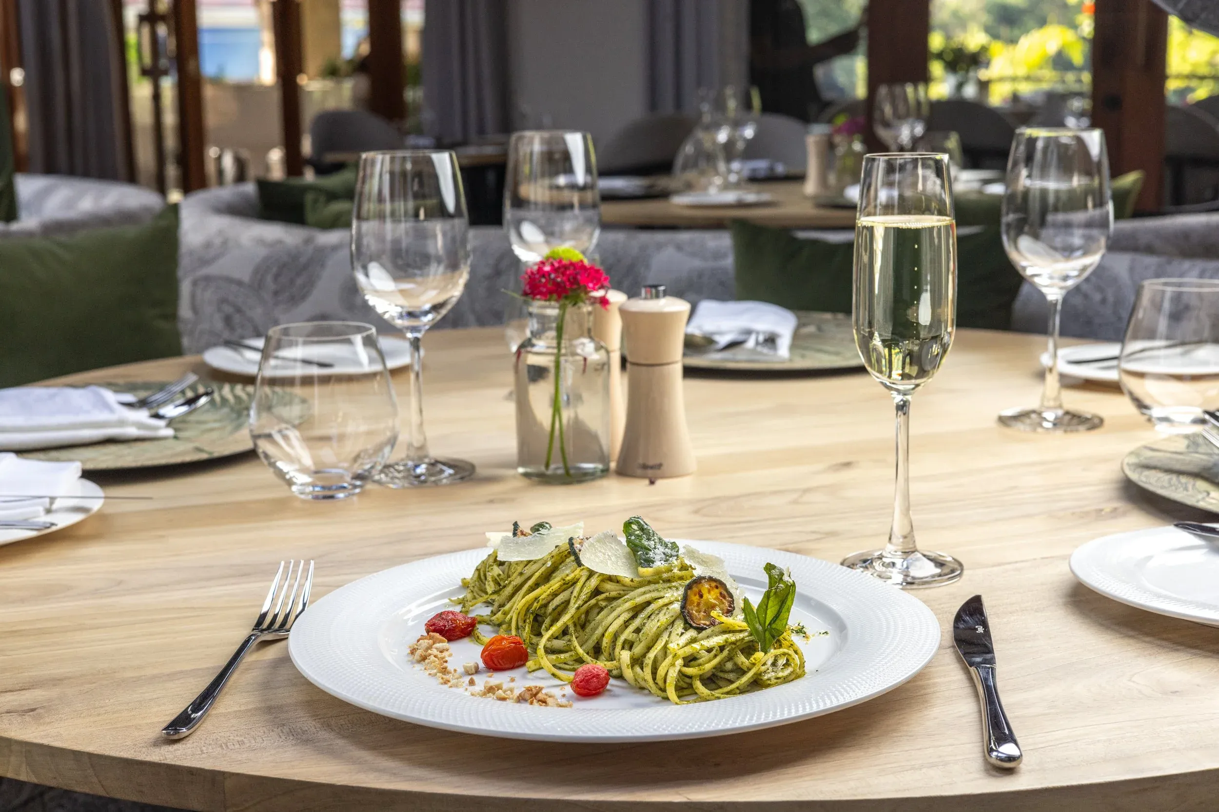 Pesto pasta with cherry tomatoes and a glass of champagne