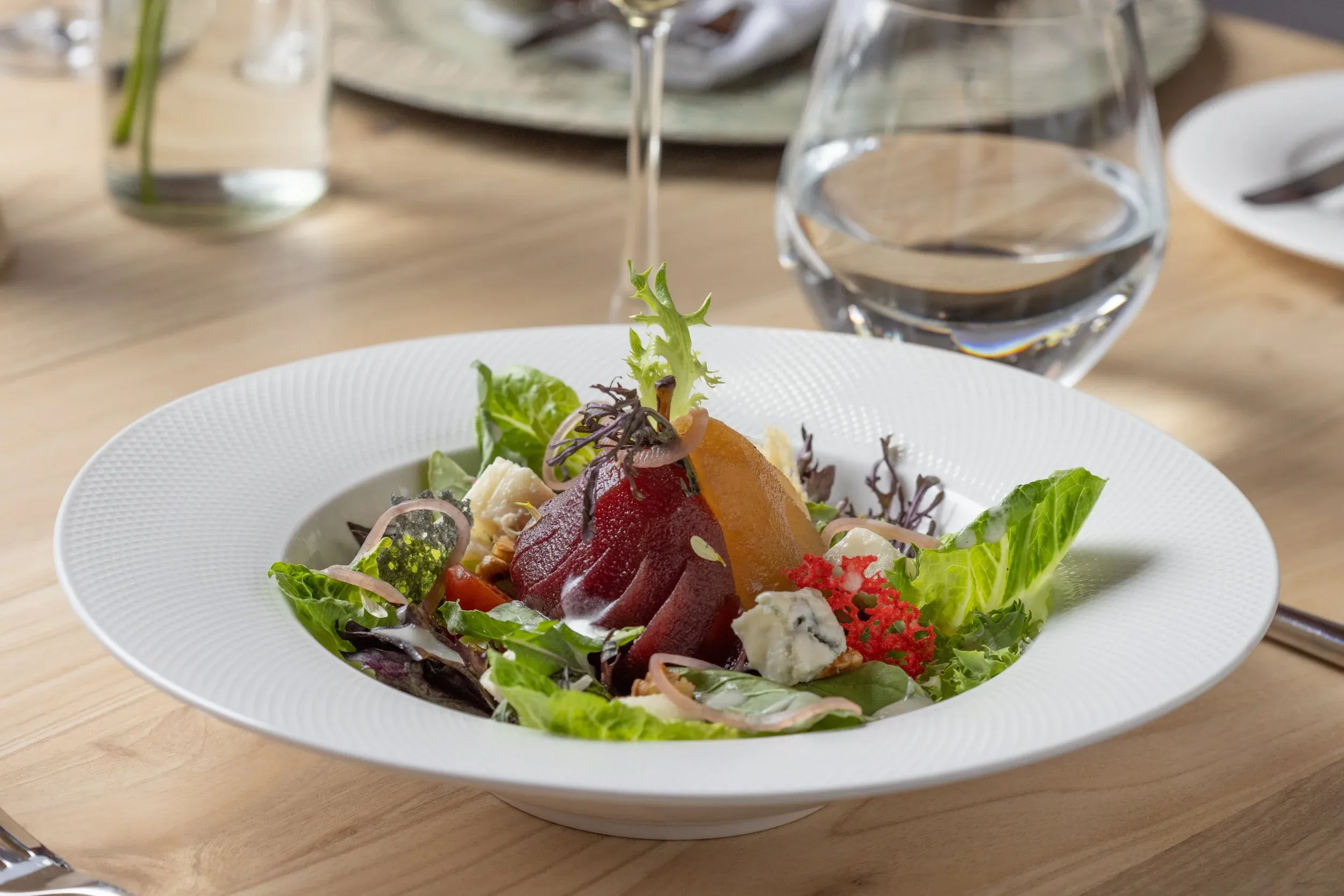 Beetroot, pear and blue cheese salad in a wide white bowl